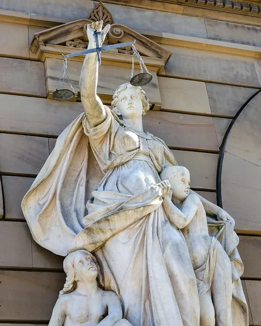 Statue de la Justice protégeant des enfants sur la façade d'un tribunal