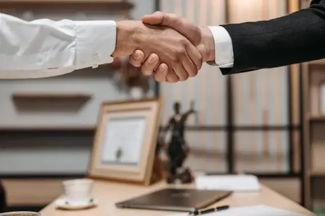 Poignée de main entre un avocat et son client dans un cabinet